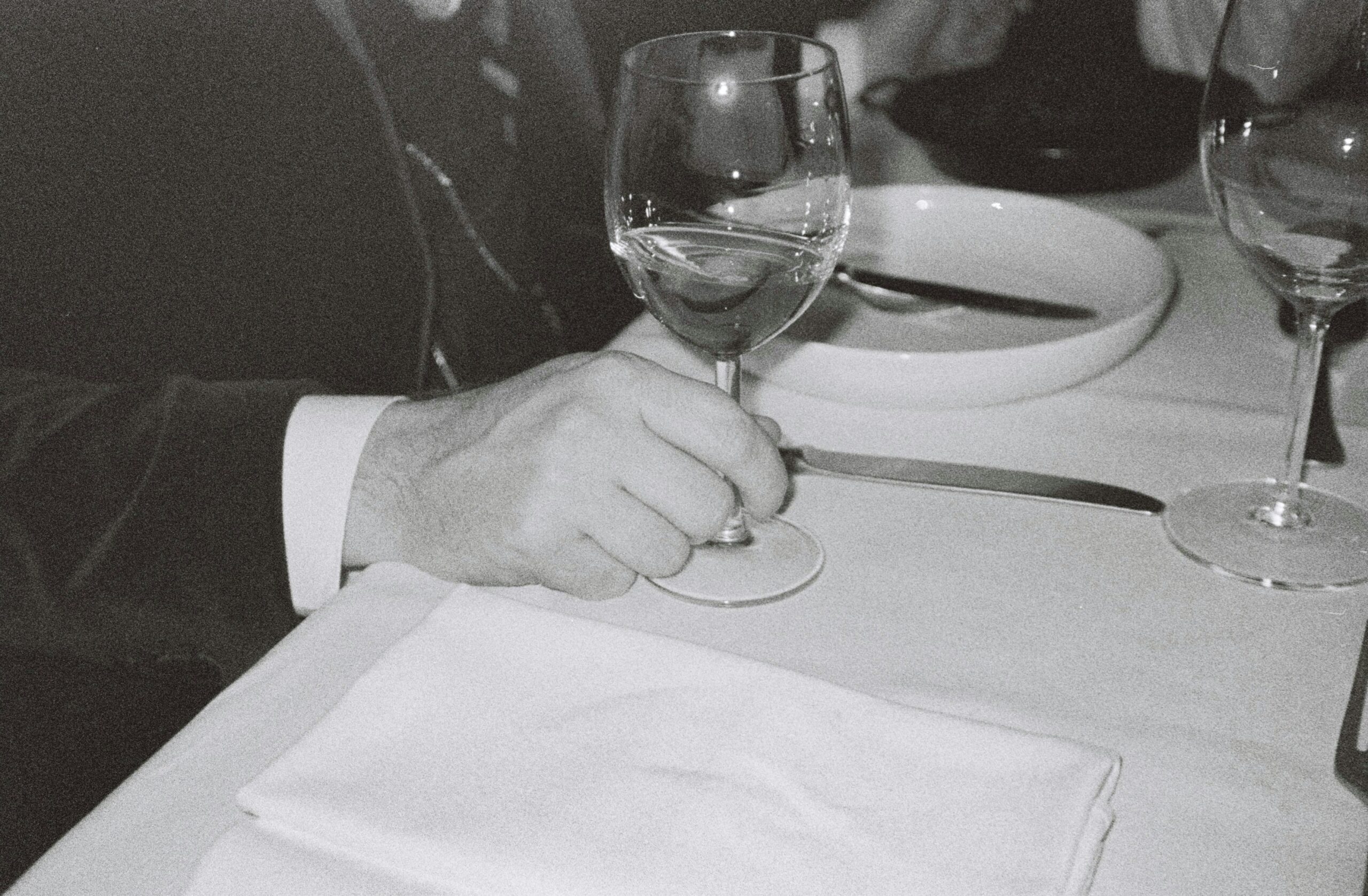 A man wearing a polished silver Rolex fashion watch paired with a navy suit and tie