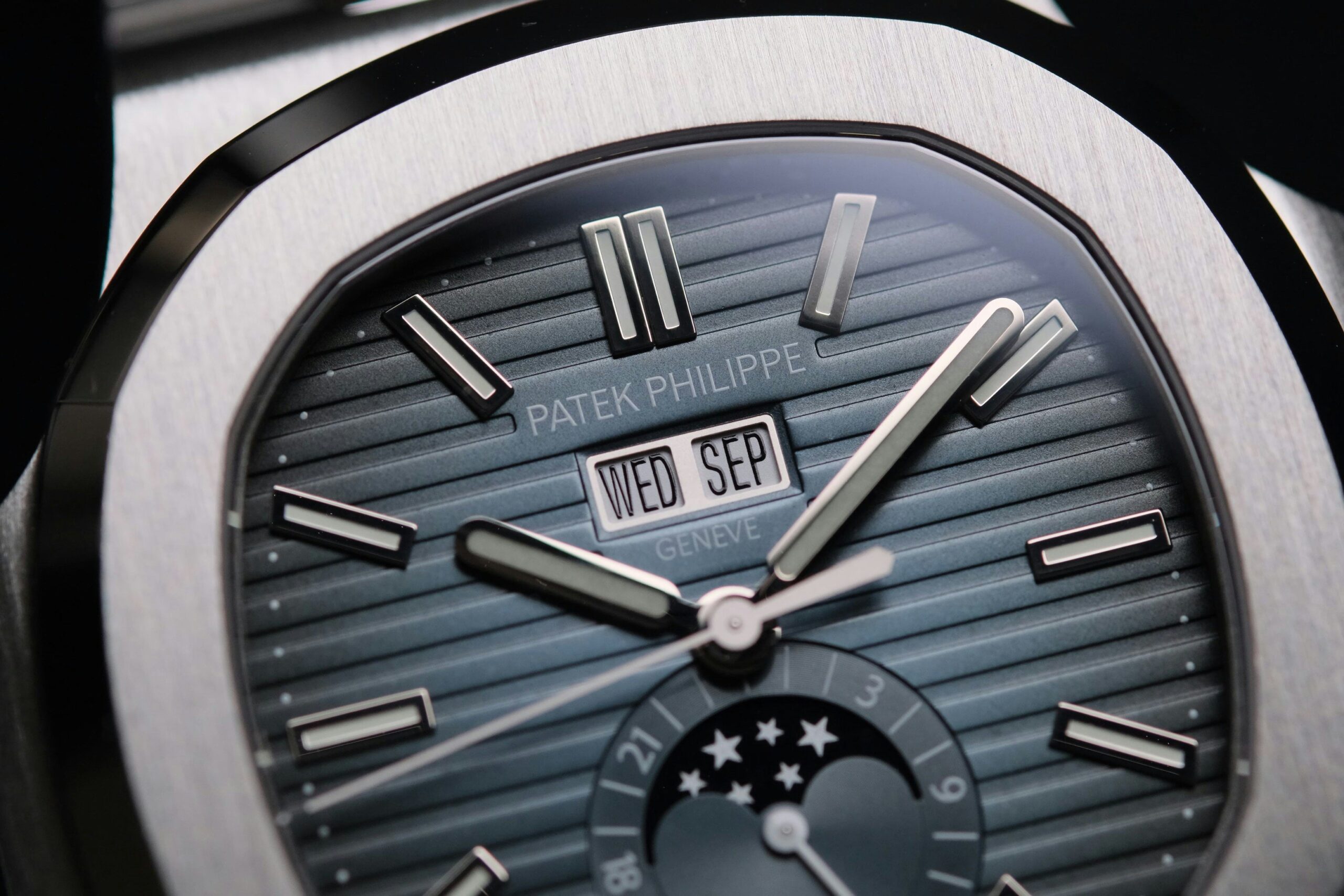 A sleek titanium watch worn on a person's wrist against a minimalist background