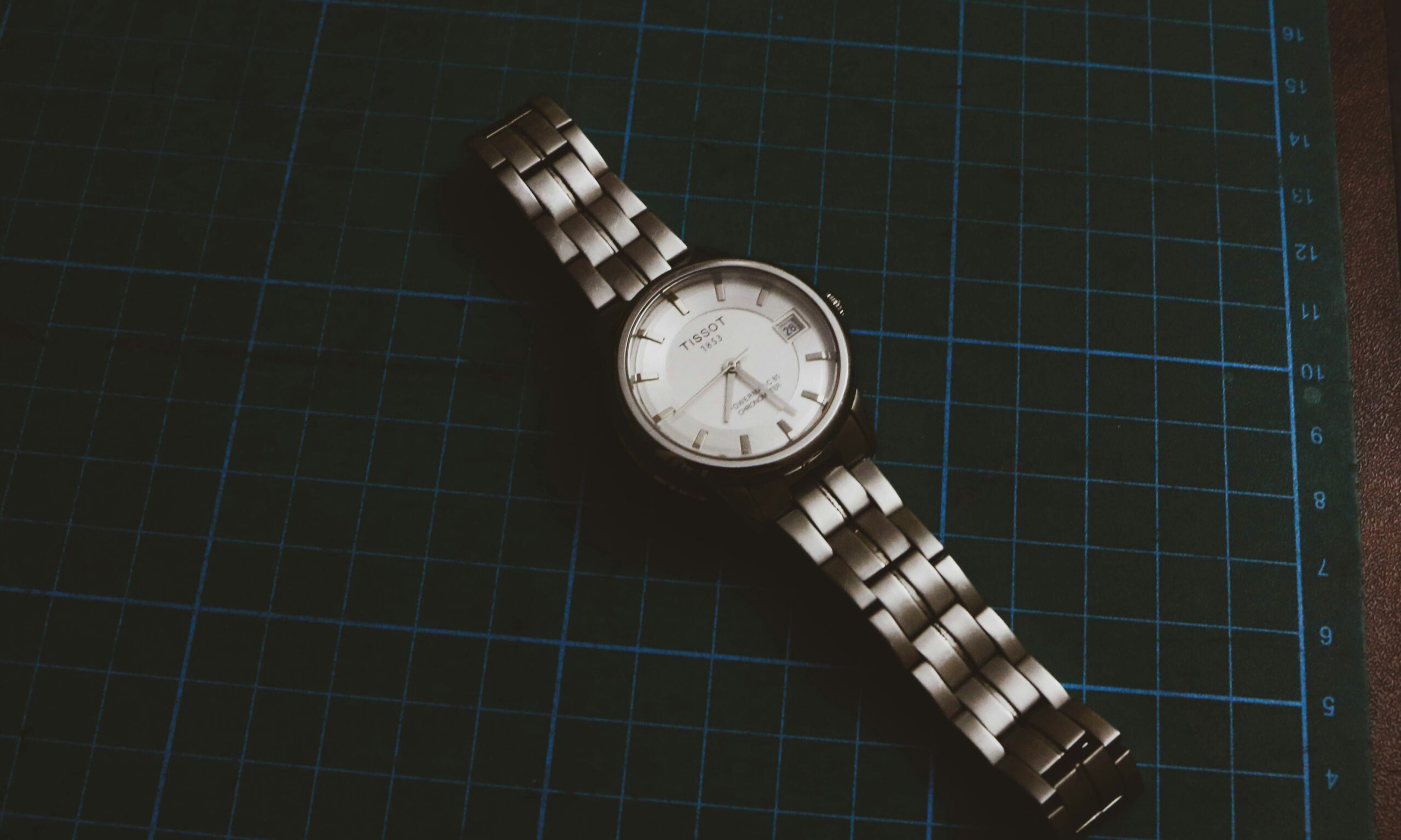 A close-up shot of a person cleaning a sapphire crystal watch with a microfiber cloth.
