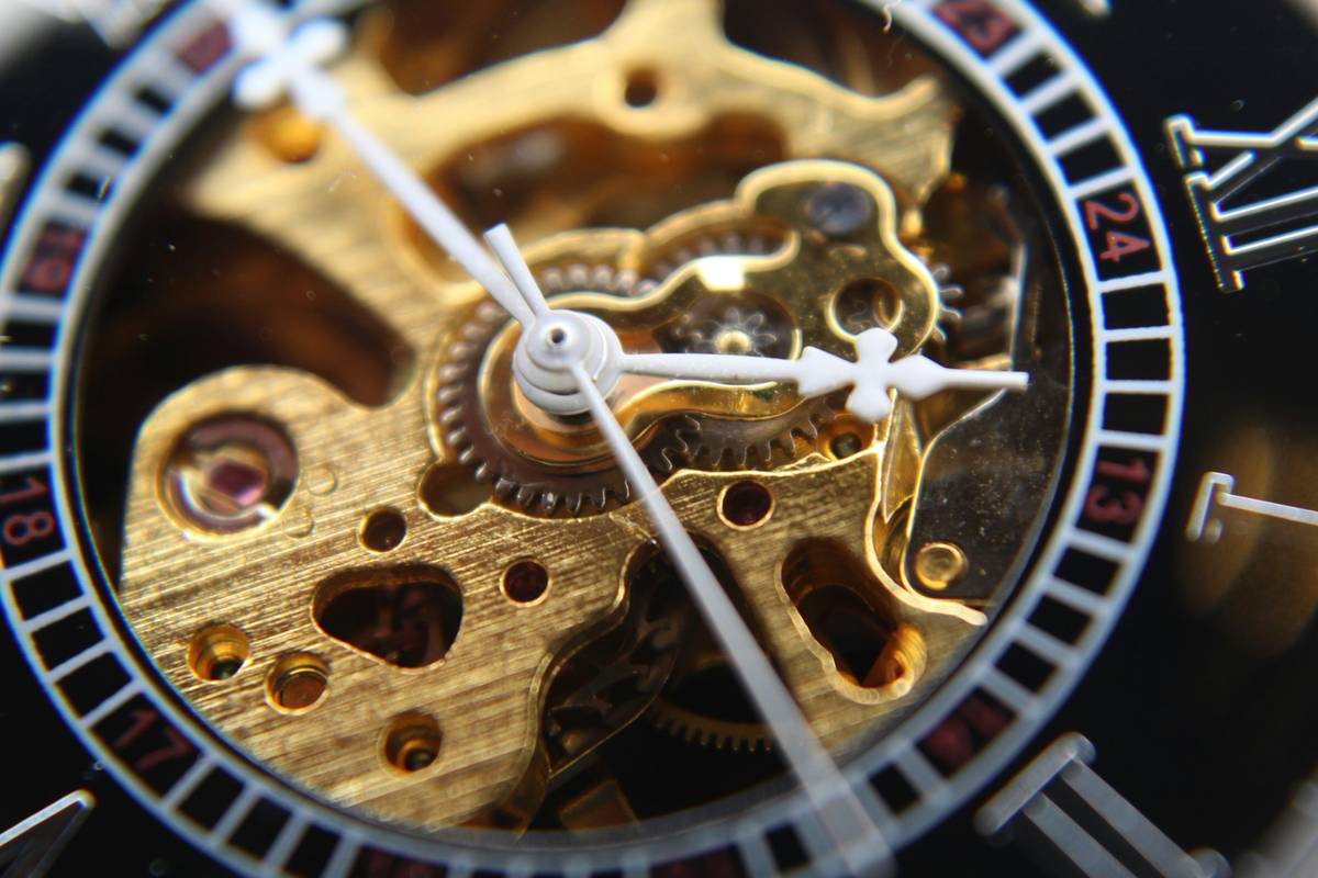 Close-up image of a skeleton watch mechanism on black background