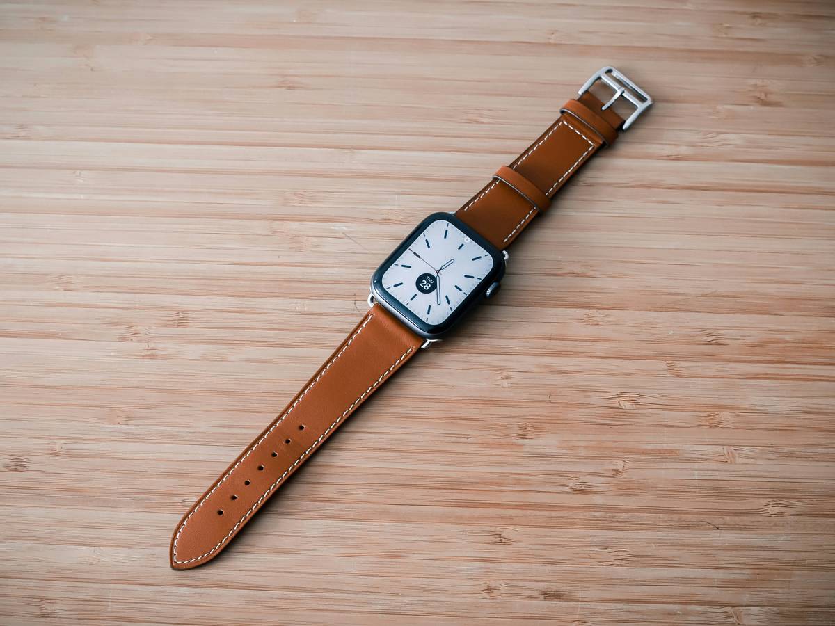 Close-up of a wooden watch face surrounded by natural elements