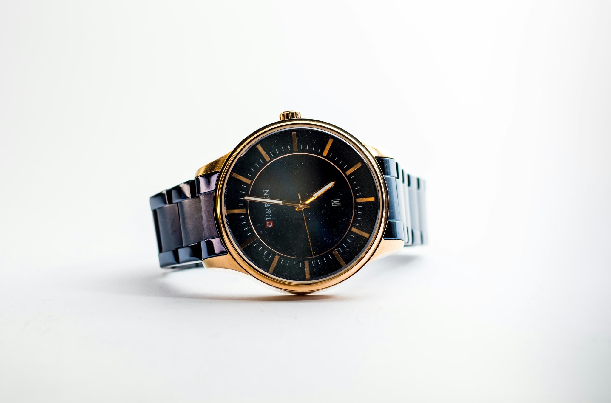 Influencer wearing a fashion watch with a midnight-blue leather strap against a backdrop of gadgets