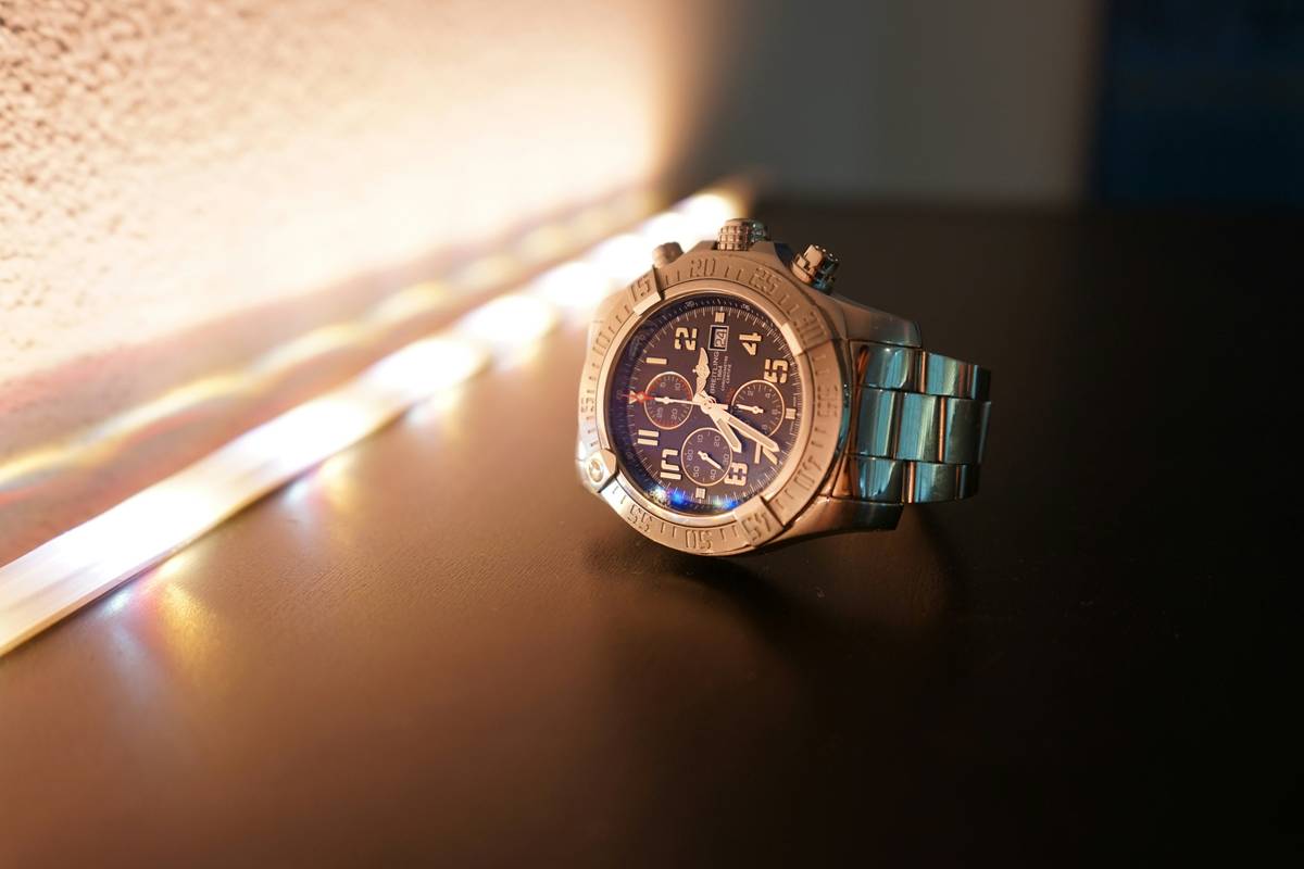 A close-up shot of three vibrant metallic finish watches side by side on a white background, showcasing different hues such as silver, rose gold, and bronze.