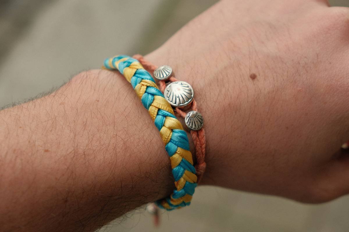 Multiple colorful watches arranged on a wooden surface with flowers.