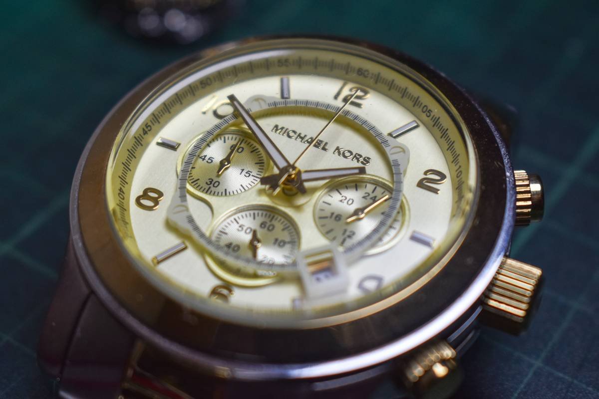 Close-up shot of a jeweler examining a vintage watch under a magnifying lens