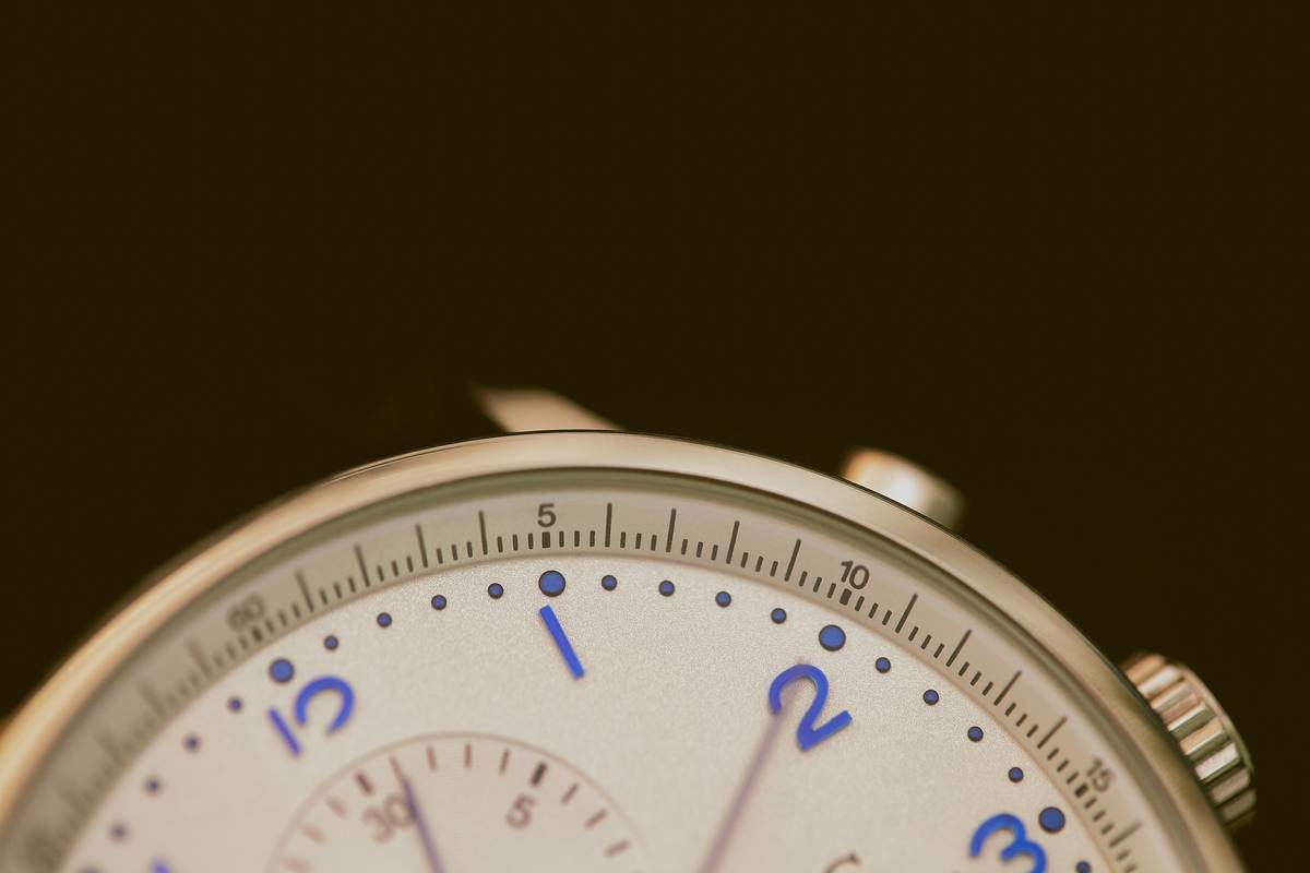 Close-up image of a sleek lugless dress watch on a wooden table