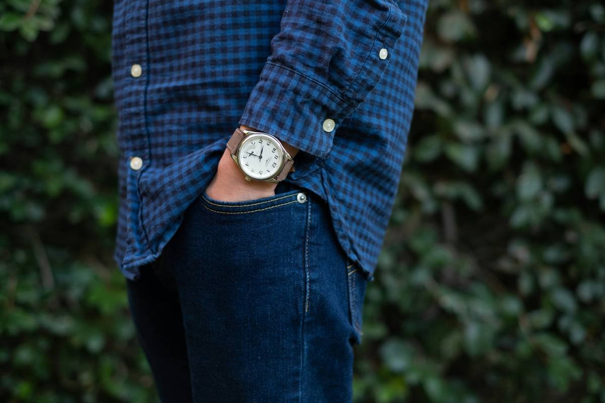 Woman pairing rose gold fashion watch with blush dress illustrating how to style watches with outfit